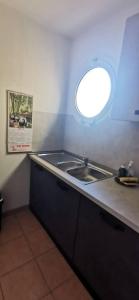 a kitchen with a sink and a round window at Villa Azzurra superbe 2P centrale et vu mer in Menton