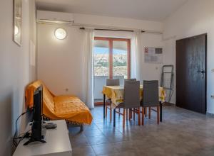 a living room with a table and chairs and a television at Barba Damir in Pag