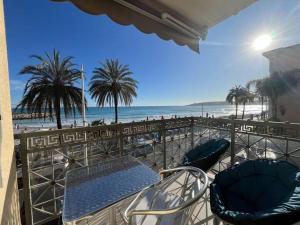 芒通的住宿－Villa Azzurra superbe 2P centrale et vu mer，一个带椅子的阳台,享有海滩美景