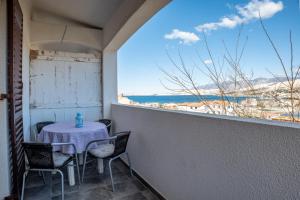 a table and chairs on a balcony with a view of the beach at Barba Damir in Pag
