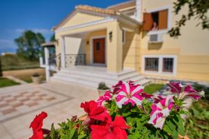 a house with red flowers in front of a house at Utopia Beach Villa in Litherés