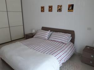 a bed in a bedroom with pictures on the wall at A casa di Elsa in Rome