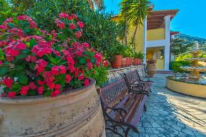 a park bench with pink flowers in a planter at Sea View Village in Vasilikos