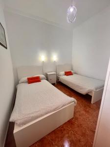two beds in a small room with white walls at Aceró Home in Los Llanos de Aridane
