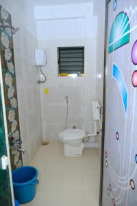 a small bathroom with a toilet and a window at Aashray Guestroom 