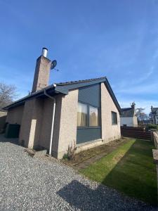 a brick house with a window and a chimney at Cathwill - Cosy 4 Star Cottage - Cairngorm National Park in Newtonmore