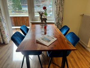 a dining room table with chairs and a vase of flowers at Gemütliche und moderne Ferienwohnung in Tirol, FeWo 5 in Thiersee