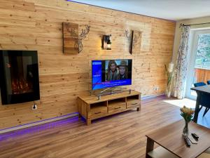 a living room with a flat screen tv on a wooden wall at Gemütliche und moderne Ferienwohnung in Tirol, FeWo 5 in Thiersee