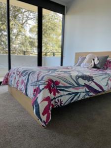 a bedroom with a bed with a flower patterned blanket at Brand New 2BR2Bath Family Home Manuka Inner South in Kingston 
