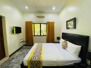 MVR Mariegold Resort في Suba: غرفة نوم بسرير كبير ونافذة