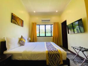 Un dormitorio con una cama grande y una ventana en Mariegold Villa Resort, en Suba
