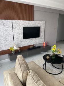 a living room with a tv and a couch and a table at Smarthome Serviced Apartment in Nairobi