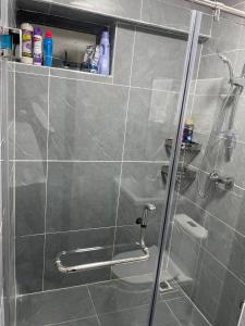 a shower with a glass door in a bathroom at Smarthome Serviced Apartment in Nairobi