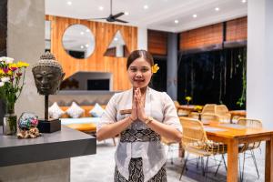a woman standing in a living room with her hands in front at The Nani in Ubud