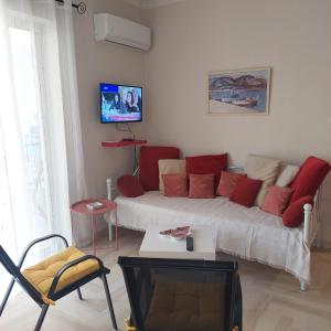 ein Wohnzimmer mit einem Sofa und einem TV in der Unterkunft Family Apartment in Patras