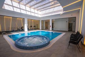 a large swimming pool in a building with a glass ceiling at Le Bosquet in Shaqra