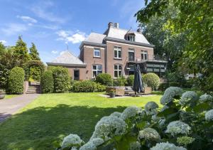 a large brick house with a green yard at B&B Villa van Voss in Etten-Leur