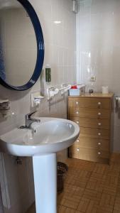 y baño con lavabo blanco y espejo. en Apartamento Turístico Dalmacia, en Gata