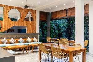 a dining room with wooden tables and chairs at The Nani in Ubud