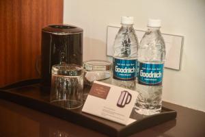 two bottles of water sitting on a shelf in a hotel room at Hotel Old Urban Guest House in Kolhapur