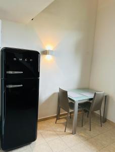 Piccolo appartamento a Prato في براتو: غرفة طعام مع طاولة وثلاجة سوداء