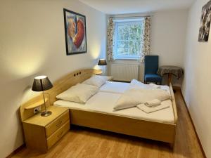 1 dormitorio pequeño con 1 cama y 1 silla en Auszeit im Thierseetal, familienfreundliche Ferienwohnung, FeWo 7, en Thiersee