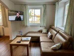 sala de estar con sofá y TV de pantalla plana en Auszeit im Thierseetal, familienfreundliche Ferienwohnung, FeWo 7, en Thiersee