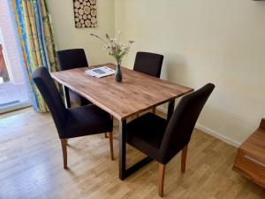 a dining room table with chairs and a vase of flowers on it at Aktivurlaub, Wandern, Biken und Baden in Tirol, FeWo 13 in Thiersee