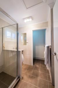 a bathroom with a shower and a glass door at Bottletree Apartments on Garget in Toowoomba