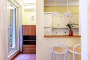 a kitchen with white cabinets and a table with chairs at Casa Rio in Rome