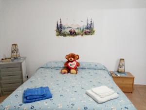 un ours en peluche assis au-dessus d'un lit dans l'établissement Casa dell'orso, à Rocca di Botte