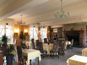 comedor con mesas y sillas y chimenea en Logis hôtel & Restaurant - Auberge de la Forêt, en Hazebrouck