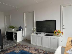 a living room with a flat screen tv on a white cabinet at The favorite room in a shared apartment in Nacka