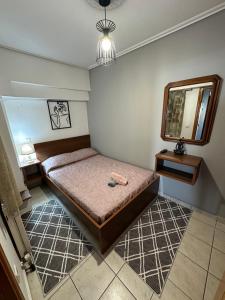 um pequeno quarto com uma cama e um espelho em Bratis House 3 em Vartholomión