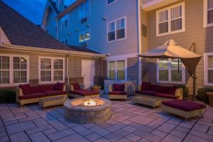 een terras met een vuurplaats met banken en een parasol bij Residence Inn by Marriott Rocky Mount in Rocky Mount