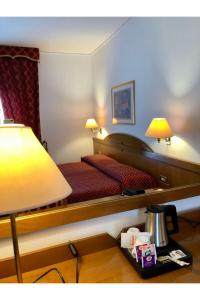 a hotel room with a bed and a table with a lamp at Hotel Arcadia in Macerata