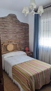 1 dormitorio con cama y pared de ladrillo en Apartamento Turístico Dalmacia, en Gata