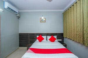 a bedroom with a bed with red pillows at Flagship White Fort Near Lalbagh Botanical Garden in Bangalore