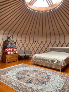 a room with a yurt with a bed and a rug at RAHMAT yurts in Bishkek +120 photos