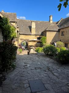 a stone walkway in front of a building at The Crown at Shipton in Shipton under Wychwood