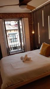 a bedroom with a large white bed with a window at Apartamentos Preciados in Madrid