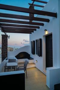 a room with a table and chairs on a balcony at Anya Suites Santorini in Akrotiri