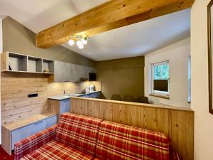 a kitchen with a bar with a red plaid couch at Arlen Lodge Appartement in Sankt Anton am Arlberg