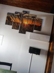 eine Wand mit fünf Bildern eines Sonnenuntergangs darauf in der Unterkunft Ubytování v komfortní chatce Štít in Chlumec nad Cidlinou
