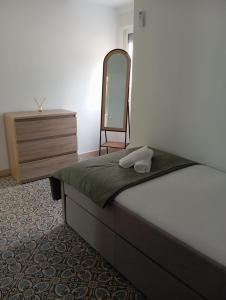 - une chambre avec un lit, un miroir et une commode dans l'établissement Gardenia Apartment, à Séville