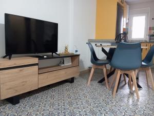 un salon avec deux chaises bleues et une télévision dans l'établissement Gardenia Apartment, à Séville