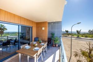 een eetkamer met een tafel en uitzicht op het strand bij Flamingo Apartment Olhão in Olhão