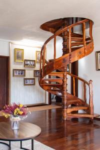 a wooden spiral staircase in a living room with a table at Casa da Lena in Batalha