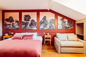 - une chambre avec des murs rouges, un lit et un canapé dans l'établissement Hôtel Maison Lacassagne Lyon, à Lyon