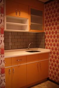 a kitchen with orange cabinets and a sink at 74 Museum Hotel in Antalya